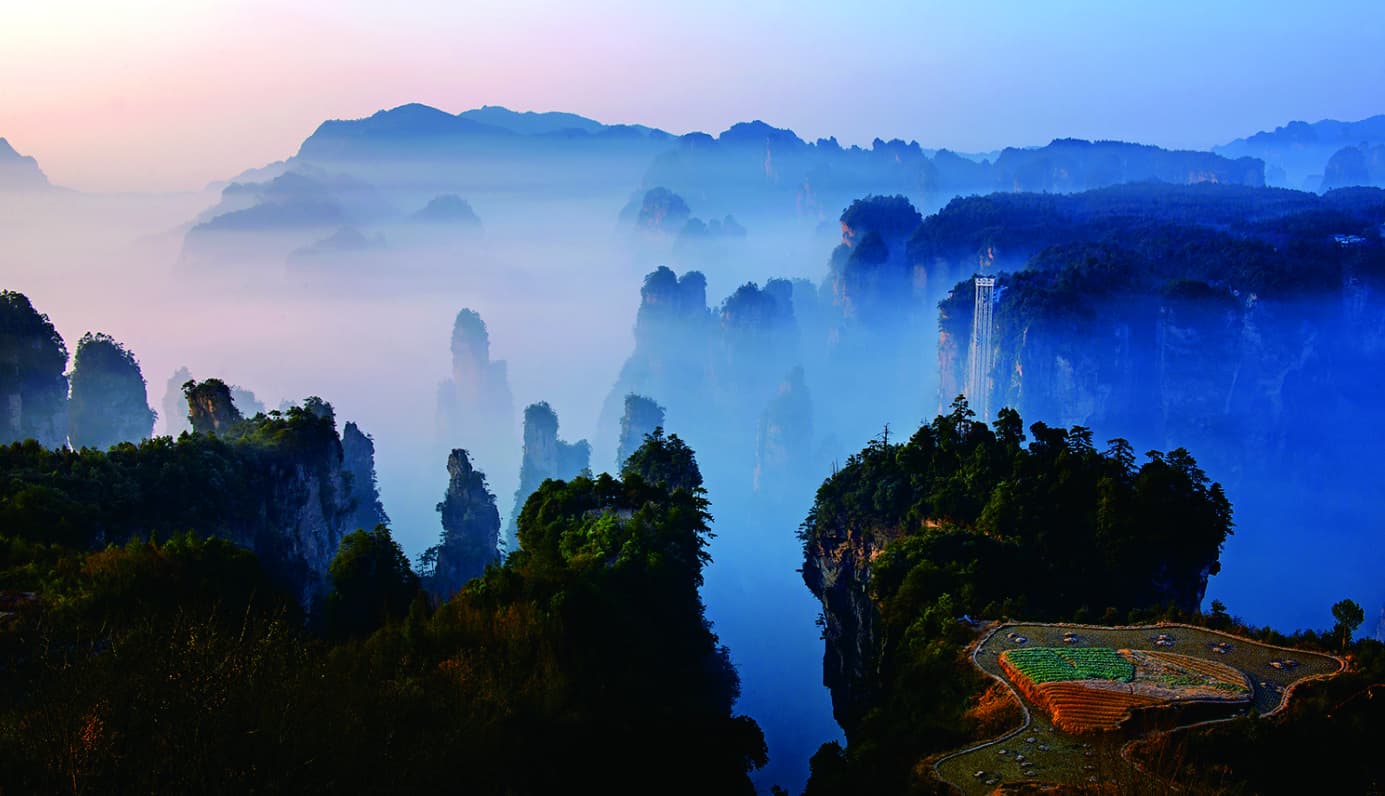 Celestial Warriors pillars emerging through blue cloud and mist